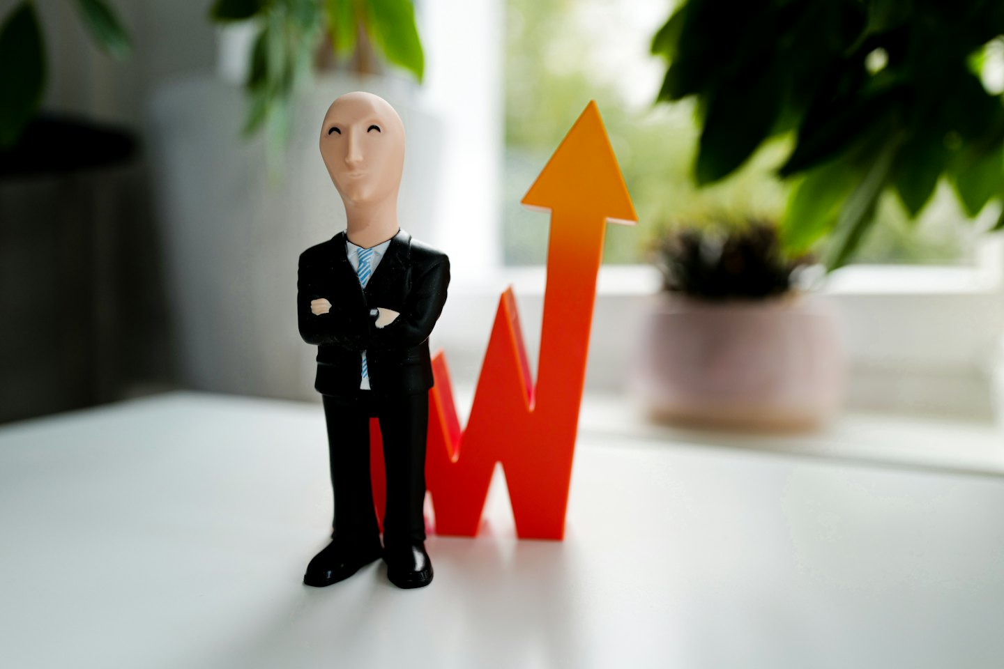 Businessman figurine with upward arrow symbolizing growth.